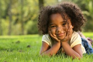 young girl laying in the grass